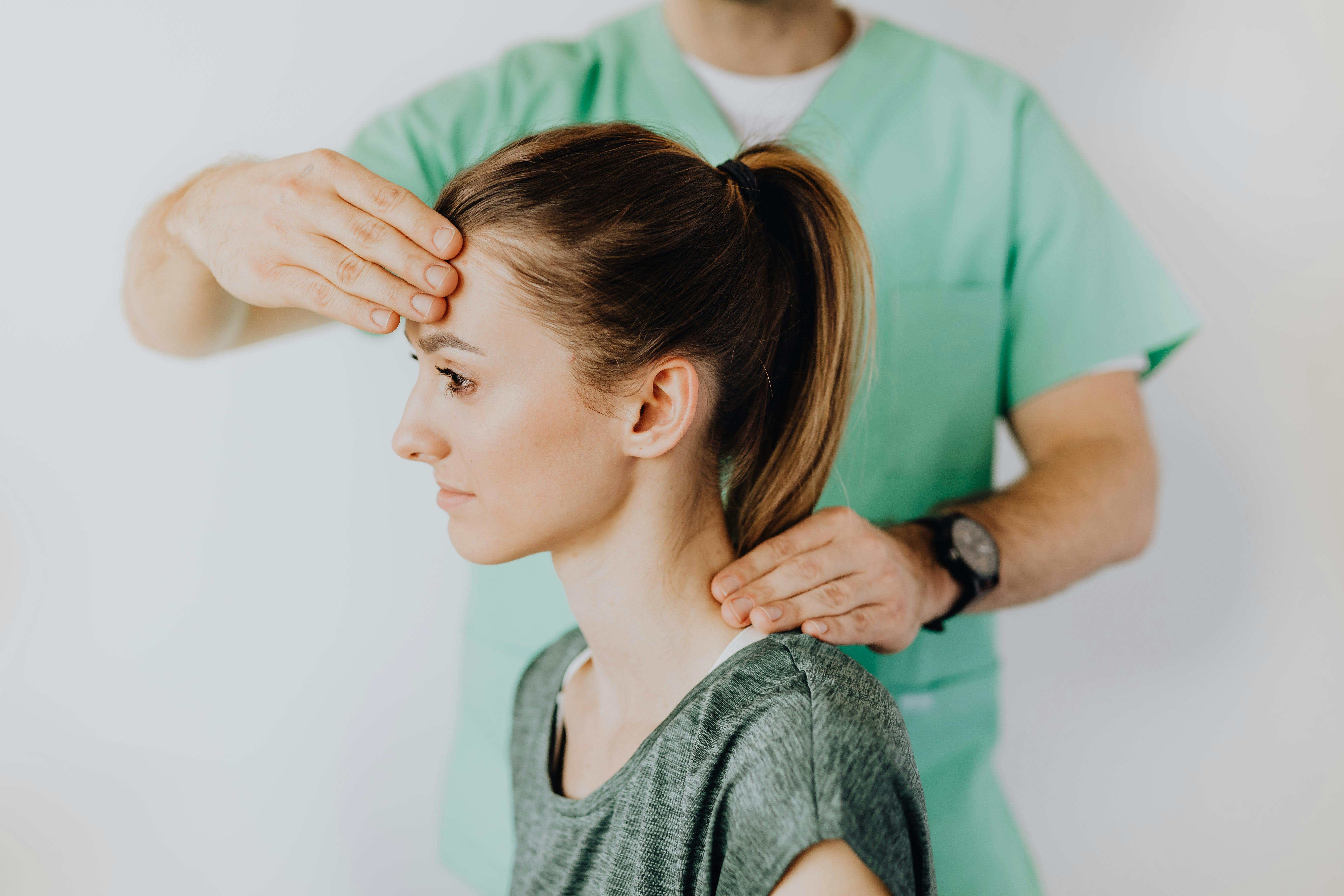 Chiropractor performing a cervical and postural assessment on a patient